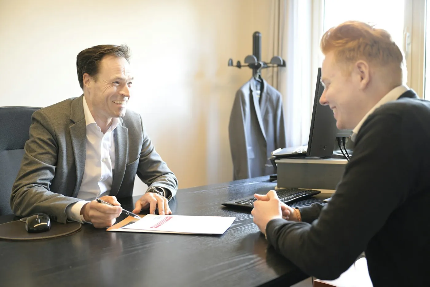 První schůzka s marketingovou agenturou: majitel agentury s perem u smlouvy a klient